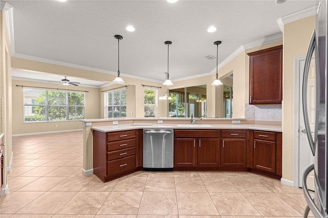 kitchen featuring sink, crown molding, light tile patterned floors, appliances with stainless steel finishes, and decorative light fixtures