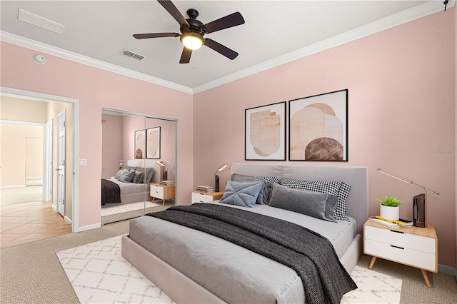 bedroom with crown molding, carpet floors, ceiling fan, and a closet