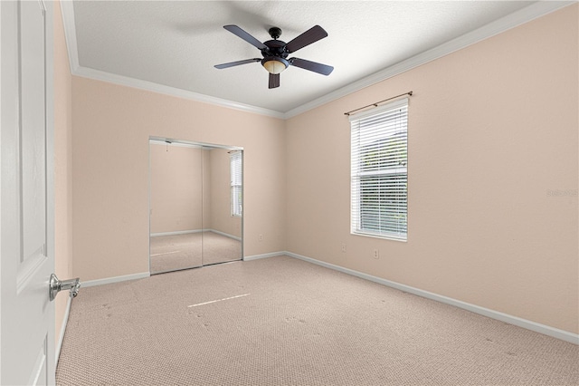 unfurnished bedroom featuring crown molding, light carpet, a closet, and a textured ceiling