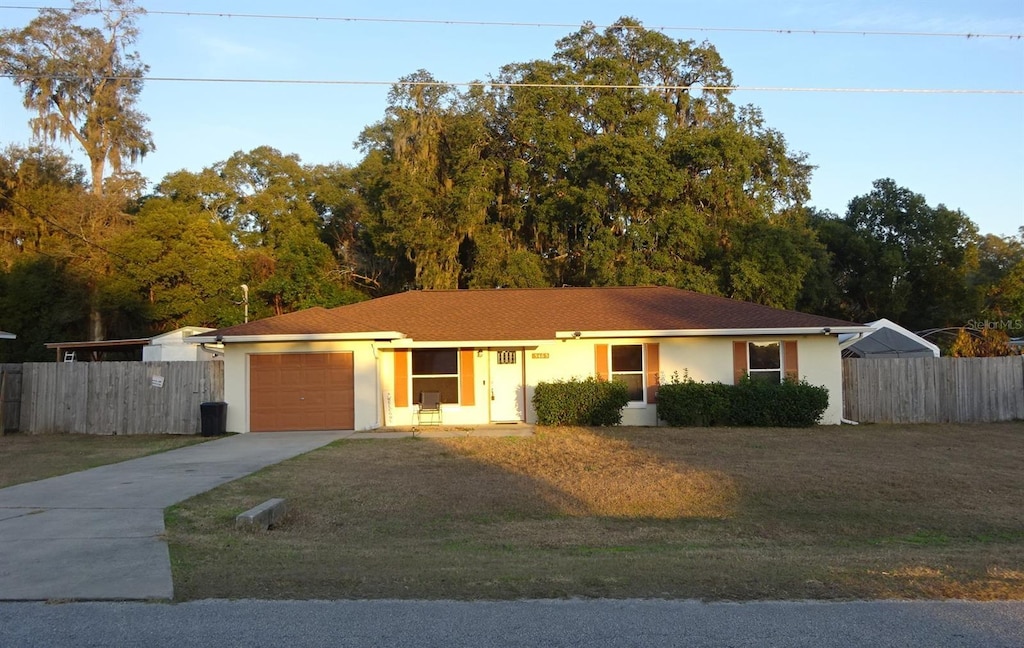 ranch-style house with a garage and a front lawn