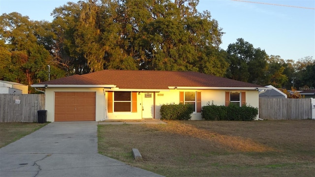 ranch-style house with a garage and a front lawn