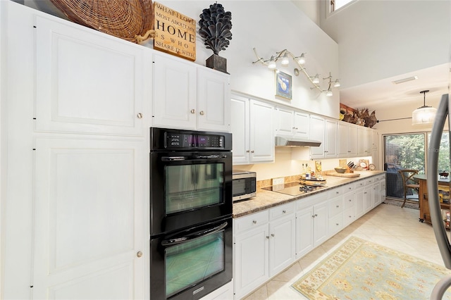 kitchen featuring pendant lighting, light tile patterned floors, white cabinetry, a towering ceiling, and black appliances