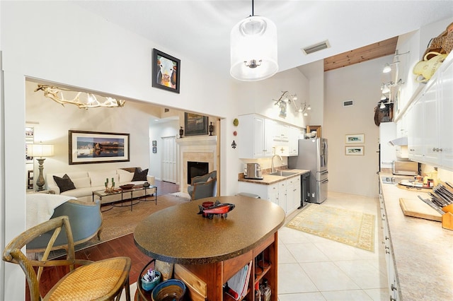 tiled dining space featuring sink and a high ceiling