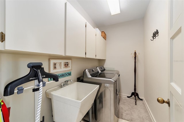 washroom featuring cabinets, independent washer and dryer, light colored carpet, and sink