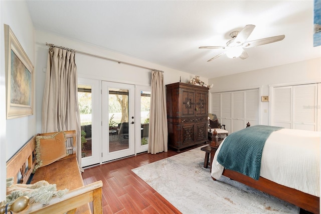 bedroom featuring dark hardwood / wood-style flooring, access to exterior, multiple closets, and ceiling fan