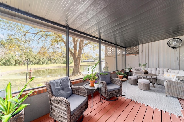 sunroom featuring a water view