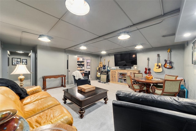 carpeted living room featuring a drop ceiling