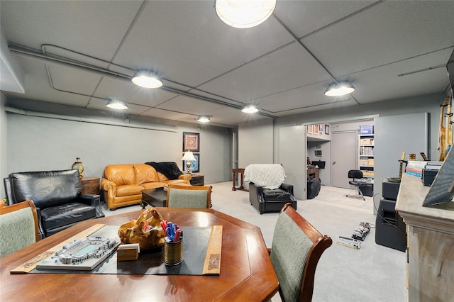 dining area with a paneled ceiling and carpet