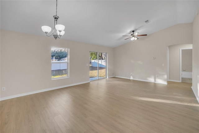 spare room with ceiling fan with notable chandelier, lofted ceiling, and light hardwood / wood-style floors