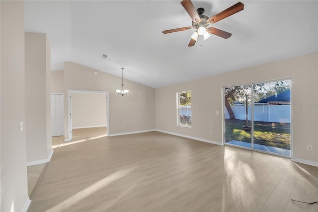 unfurnished living room with lofted ceiling, ceiling fan with notable chandelier, and light wood-type flooring