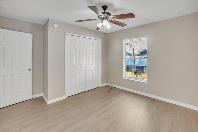 unfurnished bedroom featuring ceiling fan, light hardwood / wood-style floors, and a closet