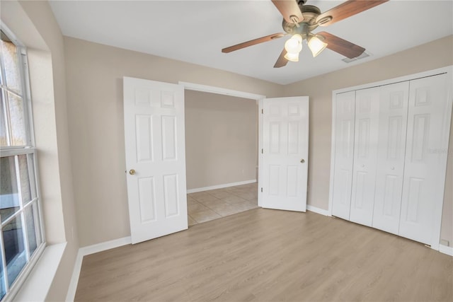 unfurnished bedroom with ceiling fan, light hardwood / wood-style floors, and a closet