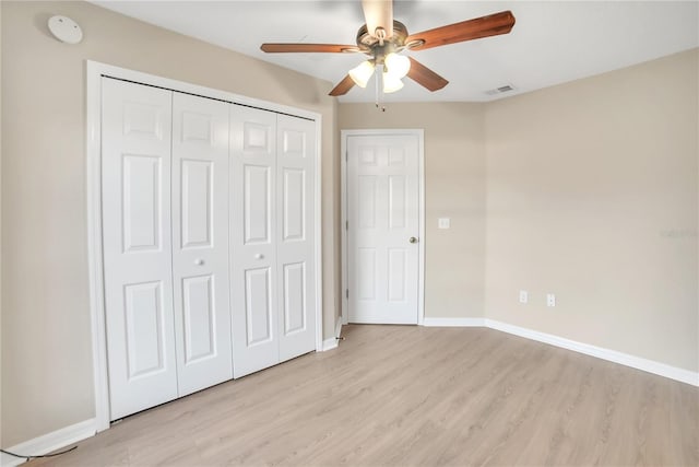 unfurnished bedroom with ceiling fan, light hardwood / wood-style floors, and a closet