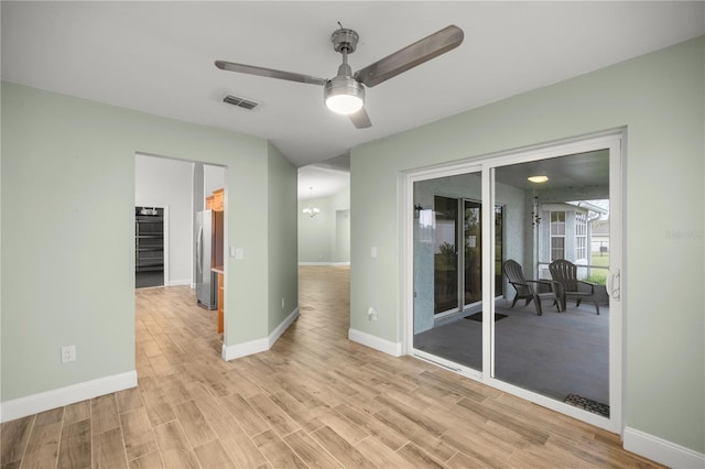 unfurnished room with visible vents, ceiling fan, light wood-style flooring, and baseboards