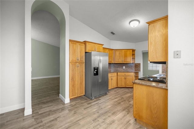 kitchen with stainless steel fridge with ice dispenser, visible vents, backsplash, light wood-style floors, and baseboards