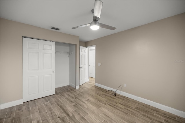 unfurnished bedroom featuring light wood-type flooring, a closet, visible vents, and baseboards