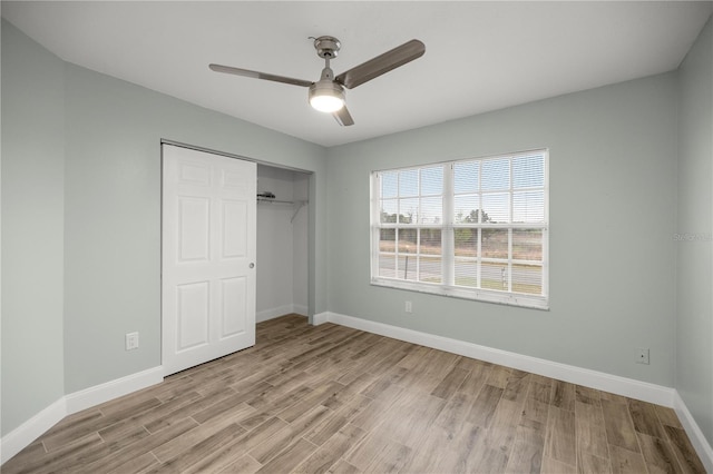 unfurnished bedroom featuring baseboards, a closet, a ceiling fan, and light wood-style floors