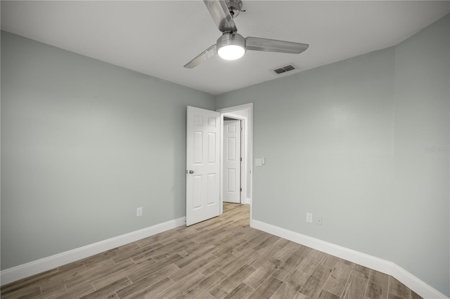 unfurnished room featuring visible vents, light wood finished floors, a ceiling fan, and baseboards