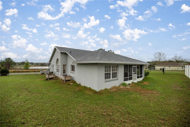 view of property exterior with entry steps, roof with shingles, fence, a yard, and stucco siding