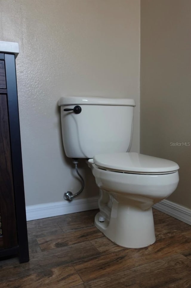 bathroom with hardwood / wood-style flooring and toilet