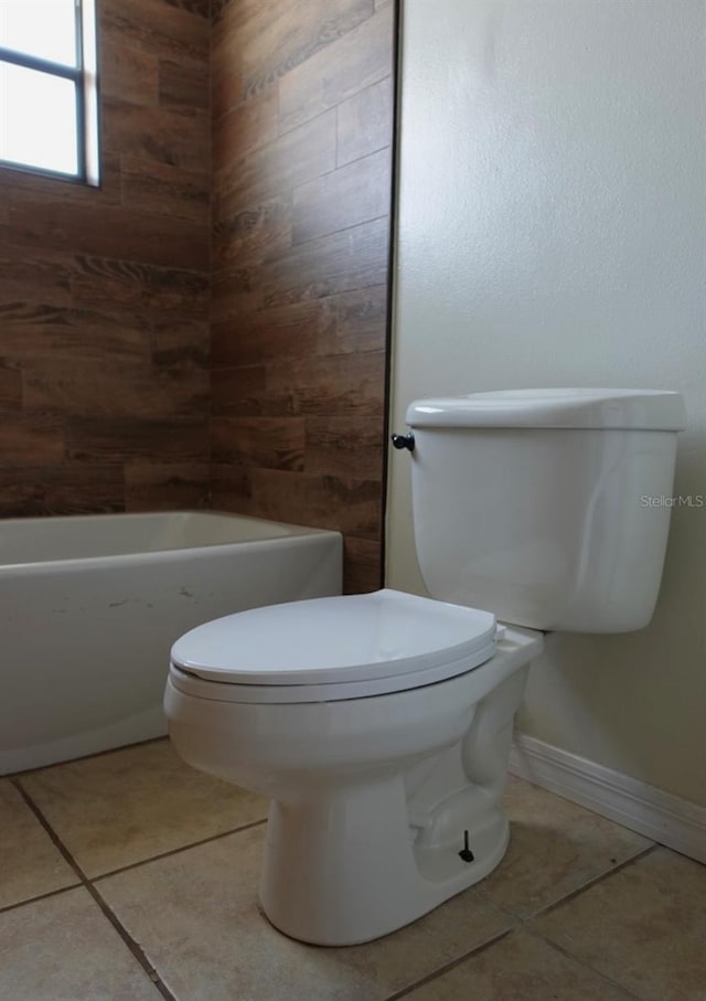 bathroom featuring toilet, tile patterned flooring, and a shower