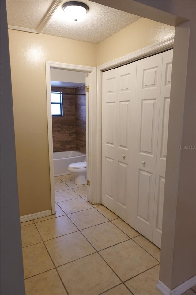 hallway featuring a textured ceiling and light tile patterned flooring