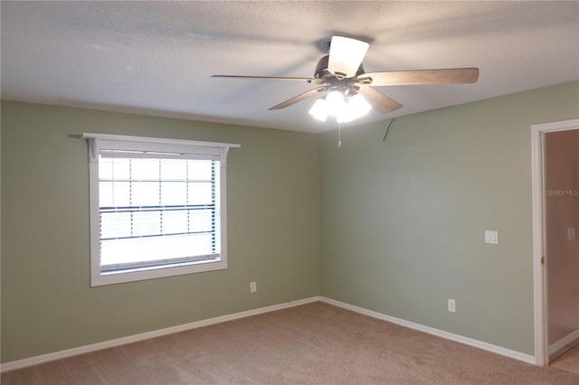 carpeted spare room with ceiling fan and a textured ceiling