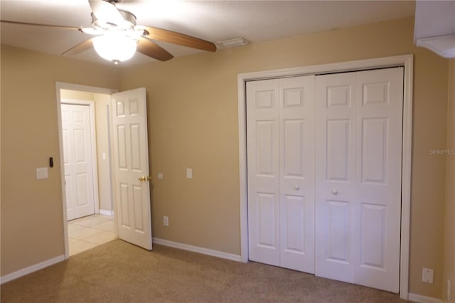 unfurnished bedroom with light carpet, ceiling fan, and a closet