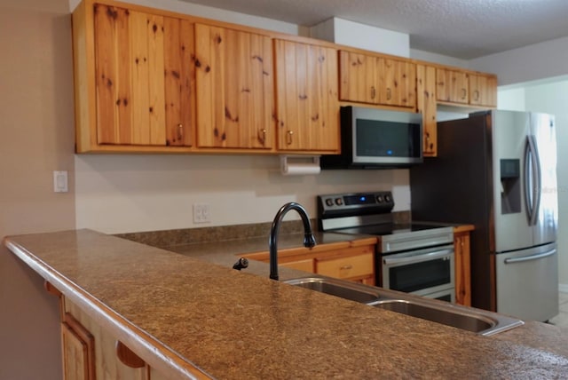 kitchen featuring appliances with stainless steel finishes and a textured ceiling