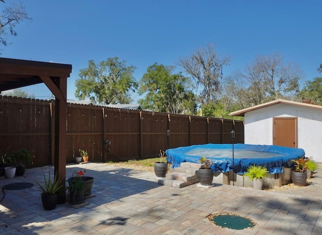 view of patio with a storage shed and a covered pool