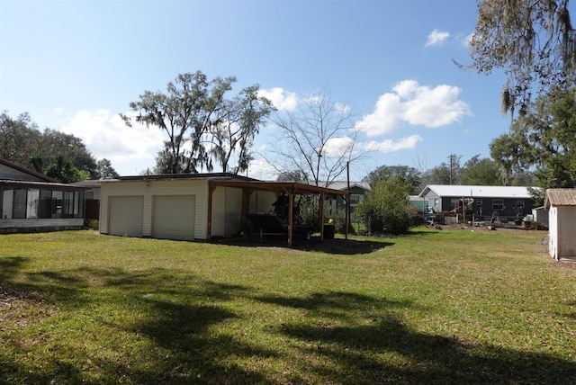 view of yard featuring a carport, a garage, and an outdoor structure