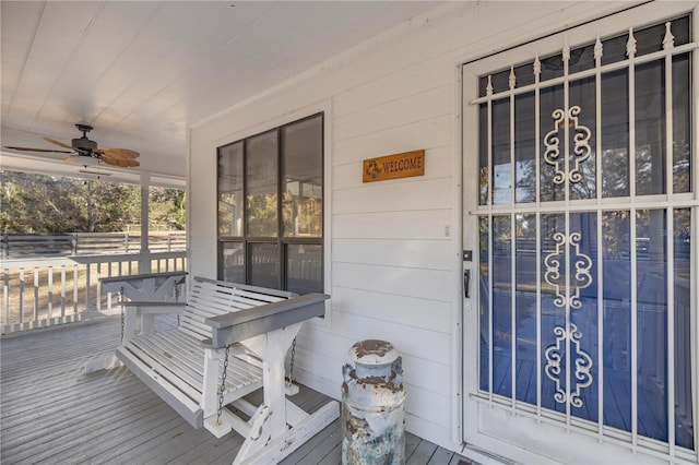 entrance to property featuring a porch and ceiling fan