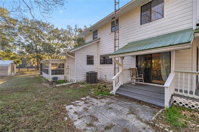 back of house featuring a wooden deck, a sunroom, and central AC unit