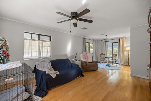 living room with hardwood / wood-style floors, ornamental molding, and ceiling fan