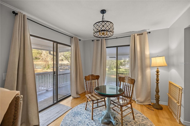 dining room featuring crown molding, light hardwood / wood-style flooring, and plenty of natural light