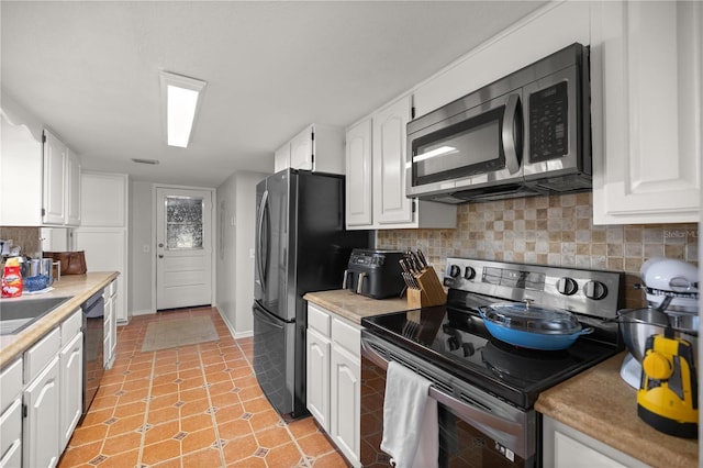 kitchen featuring tasteful backsplash, stainless steel appliances, and white cabinets