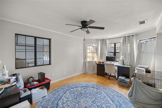 office area with ceiling fan, crown molding, a textured ceiling, and light wood-type flooring