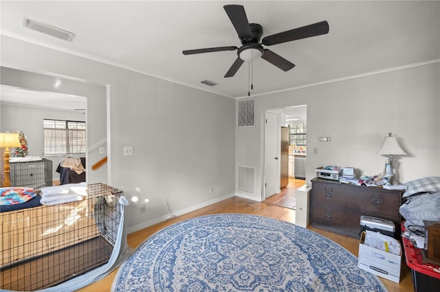 bedroom with ornamental molding, ceiling fan, and light hardwood / wood-style floors