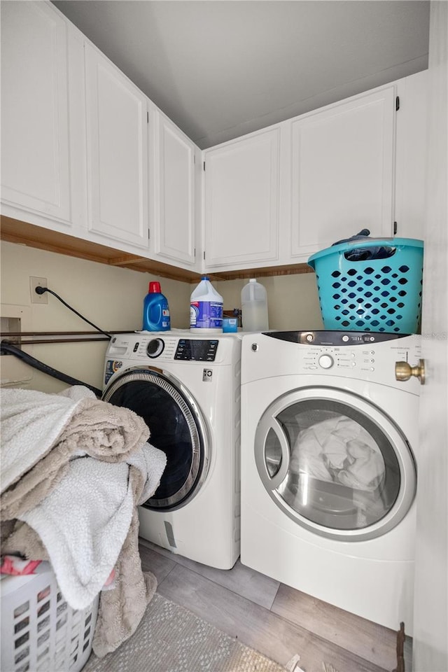 laundry room featuring cabinets and separate washer and dryer