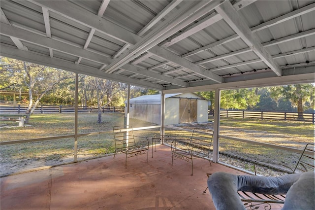 view of patio / terrace featuring a shed and a rural view