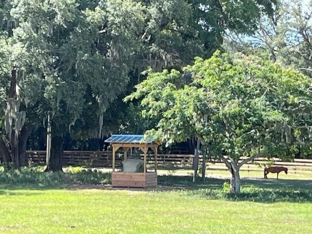 view of community featuring a lawn and fence