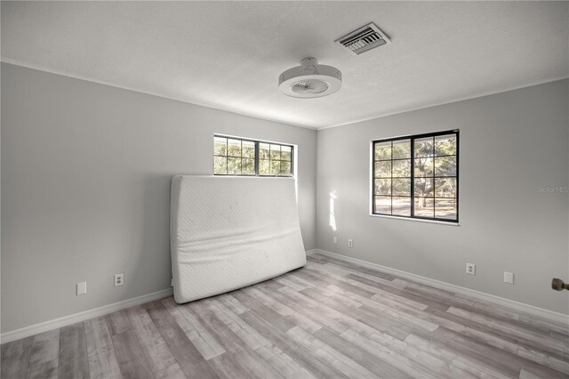 empty room featuring light hardwood / wood-style flooring and a textured ceiling