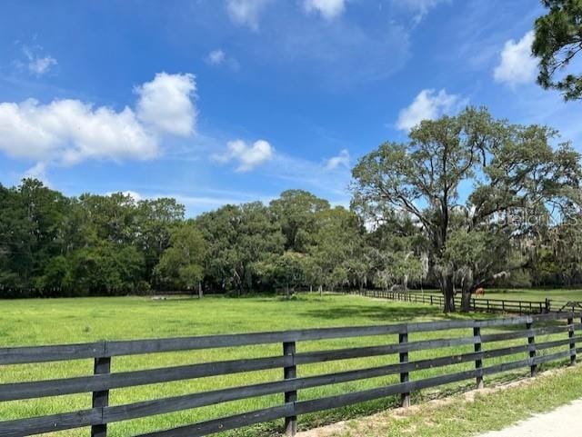 view of gate with a yard and a rural view