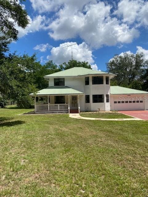 view of front of property featuring a garage, a front yard, and covered porch