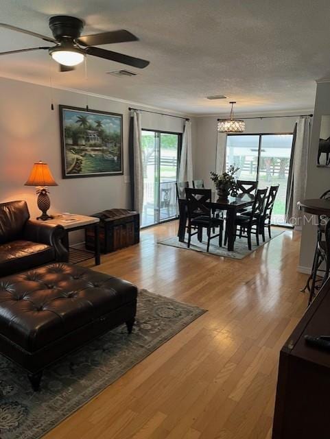 10245 SW 105th St, Ocala, FL 34481 - living area with a ceiling fan, light wood-type flooring, crown molding, and a chandelier