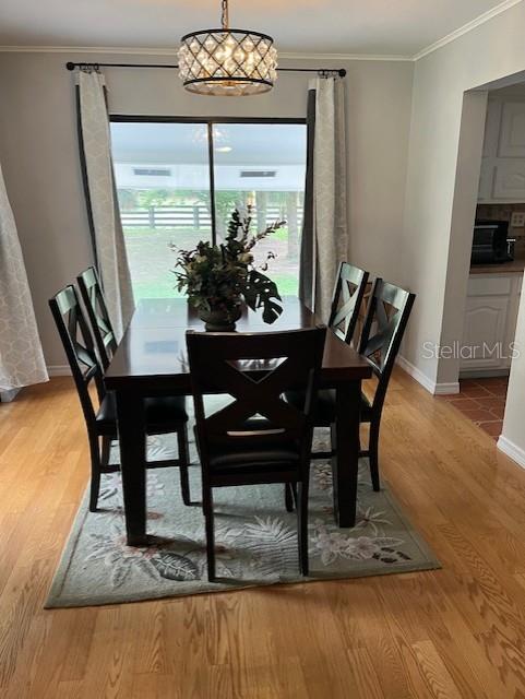 10245 SW 105th St, Ocala, FL 34481 - dining area featuring crown molding, baseboards, and wood finished floors
