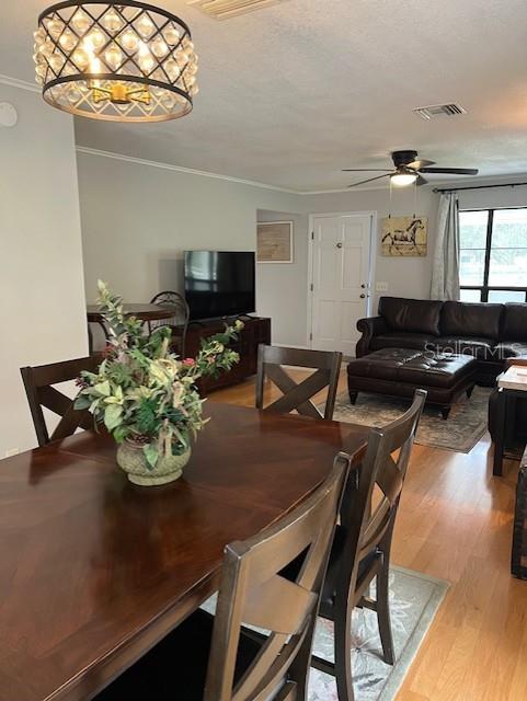 10245 SW 105th St, Ocala, FL 34481 - dining room with wood finished floors, a ceiling fan, and crown molding