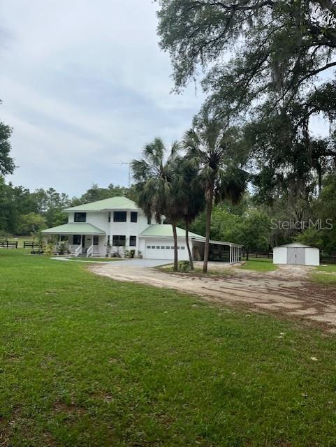 10245 SW 105th St, Ocala, FL 34481 - view of community featuring a yard, a garage, and dirt driveway