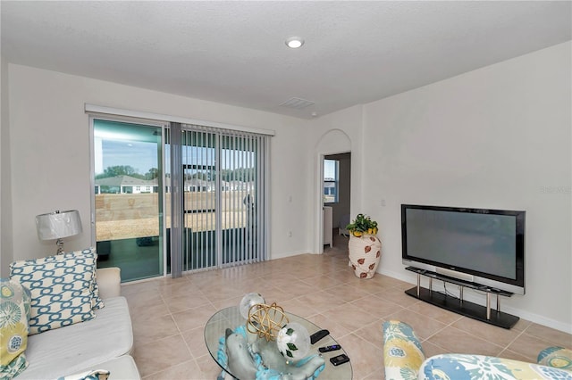 tiled living room featuring a textured ceiling