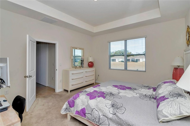 carpeted bedroom with a tray ceiling